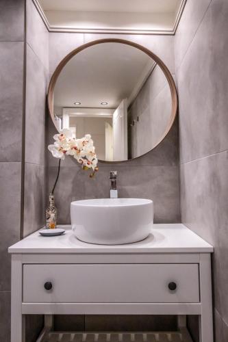 a bathroom with a white sink and a mirror at Levkosh Apartments at Lefkada's Heart in Lefkada Town