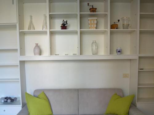 a white shelf with green pillows on a couch at A CASA DI GIANCARLA in Bologna