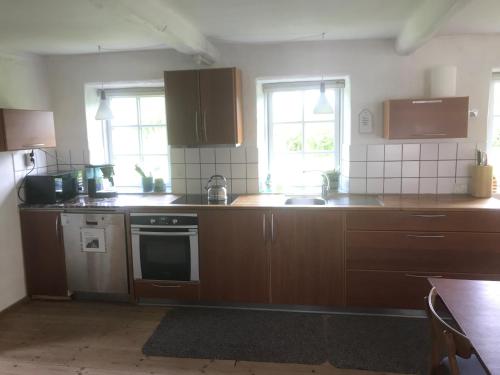 a kitchen with wooden cabinets and a stove top oven at Brunbjerg Apartments in Billund