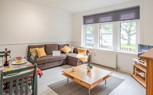 a living room with a couch and a table at Stirling Mercury Apartment - Scotland Holiday Let in Stirling