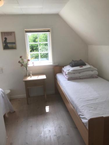 a small bedroom with two beds and a window at Brunbjerg Apartments in Billund