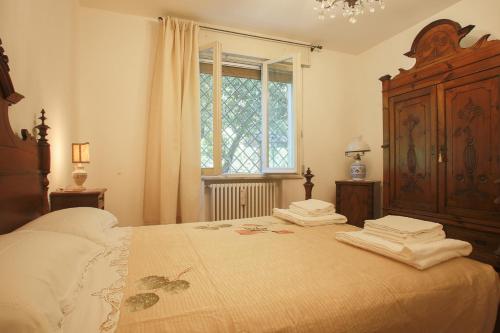 ein Schlafzimmer mit einem großen Bett und einem großen Fenster in der Unterkunft RomagnaBNB La Tana del Grillo Parlante in Cesena