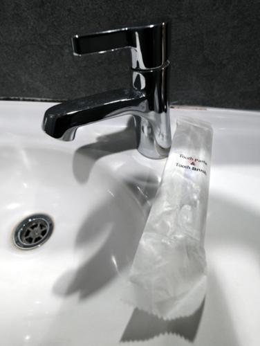 a sink faucet with a plastic bag on it at Hotel Alma in Jakarta