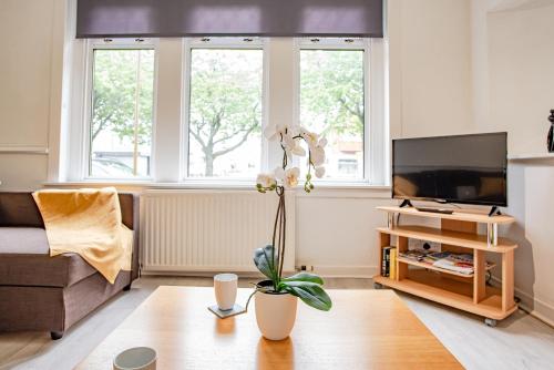 a living room with a couch and a tv at Stirling Mercury Apartment - Scotland Holiday Let in Stirling