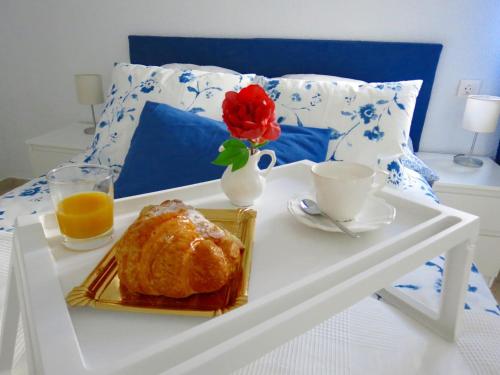 uma bandeja de pequeno-almoço com um croissant e uma chávena de sumo de laranja em Patios de San Rafael em Córdoba