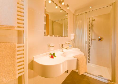 y baño blanco con lavabo y ducha. en Pension Stamserhof en Nalles