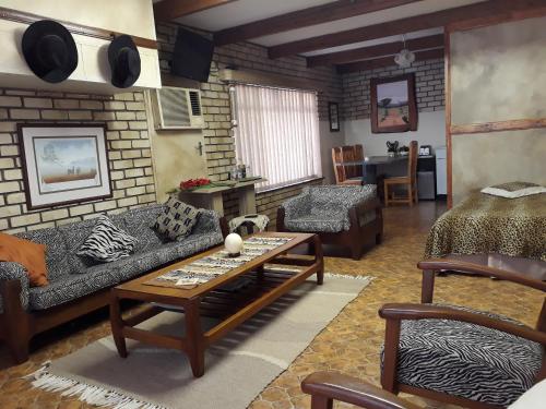 a living room with a couch and a table at Die Plasie Two-Bedroom Flat in Hartbeespoort