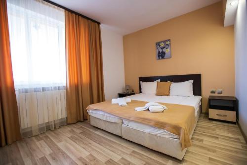 a bedroom with a bed with towels on it at Guest House Holiday in Ognyanovo