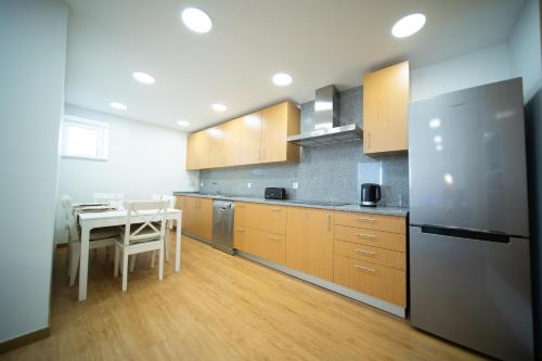 a large kitchen with a table and a refrigerator at O Melhor Sítio do Mundo - NOVO na Nazaré in Nazaré