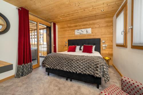 une chambre avec un lit avec des oreillers rouges dans l'établissement Colibri Uno, à Morzine