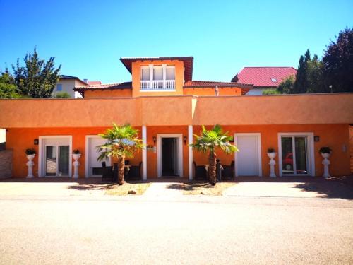 an orange building with palm trees in front of it at Villa Toscana in Steyr