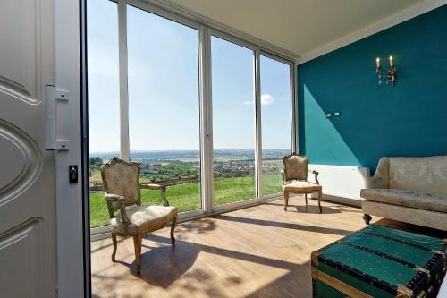 a room with large windows with chairs and a couch at Tenuta Lisetta in Monterotondo