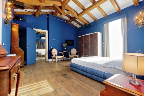 a bedroom with blue walls and a bed and a desk at Tenuta Lisetta in Monterotondo