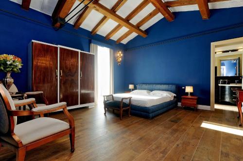 a blue bedroom with a bed and a table and chairs at Tenuta Lisetta in Monterotondo