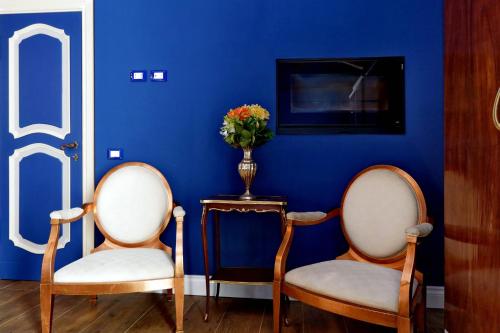 a blue room with two chairs and a vase with flowers at Tenuta Lisetta in Monterotondo