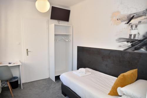 a hotel room with a bed and a desk and a bed at Hotel des Arts - Centre Cathédrale in Strasbourg