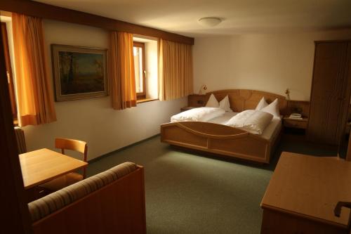 een slaapkamer met een groot bed en een tafel bij gasthof pension rössl in Nova Ponente
