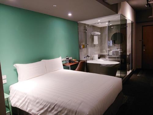 a bedroom with a large bed and a bathroom at Cho Hotel 3 in Taipei