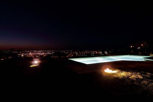 a swimming pool at night with a city in the background at Tenuta Lisetta in Monterotondo