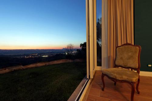 a chair sitting in front of a window with a view at Tenuta Lisetta in Monterotondo