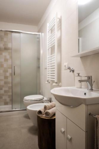 a white bathroom with a sink and a toilet at Villa Demarino in Castellana Grotte