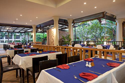 a restaurant with tables and chairs with red napkins at Deevana Patong Resort & Spa in Patong Beach