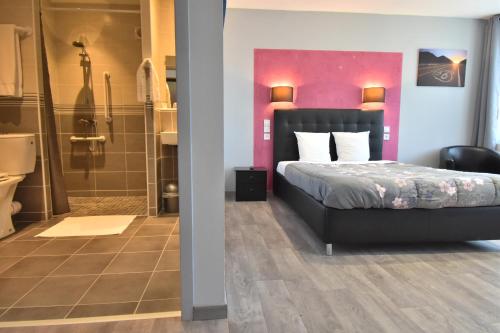 a bedroom with a bed and a bathroom with a shower at Hôtel des 2 Gares in Auxerre