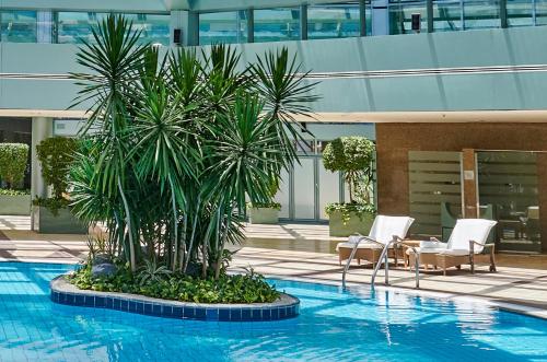 a pool with a palm tree in the middle of a building at Four Seasons Hotel Alexandria At San Stefano in Alexandria