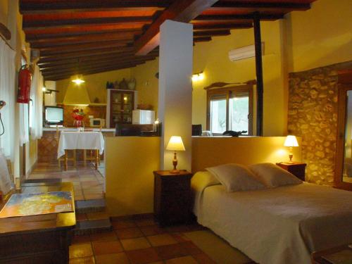 a bedroom with a bed and a kitchen with a table at Finca El Corral in Lliber