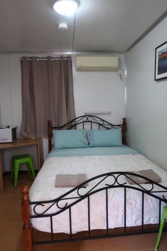 a bedroom with a bed with a iron bed frame at Mud Crab Motel in Derby