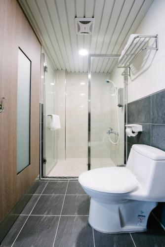 a bathroom with a toilet and a shower at The Stay Inn in Kenting
