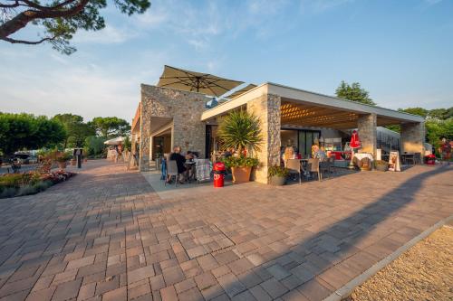a building with people sitting outside of it at Camping Fossalta in Lazise