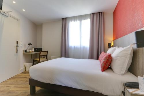 a hotel room with a large white bed and a window at Sure Hotel by Best Western Paris Gare du Nord in Paris