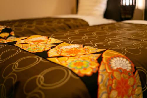 a bed with a blanket on top of it at Yufuin Lamp no Yado in Yufuin
