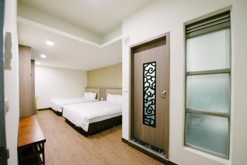 una camera con due letti e una finestra di The Stay Inn a Kenting