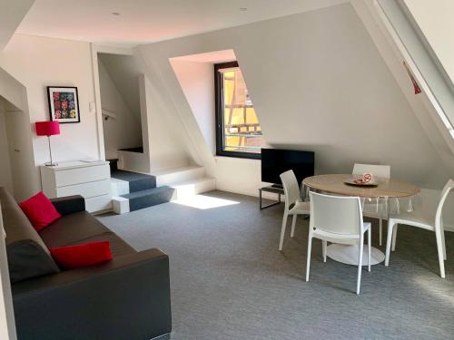 ein Wohnzimmer mit einem Sofa und einem Tisch in der Unterkunft Les Appartements du Renard in Straßburg