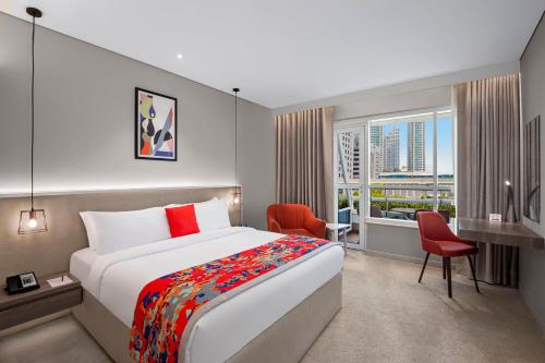 a hotel room with a large bed and a desk at Leva Hotel and Suites, Opposite Downtown in Dubai