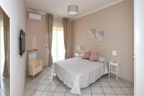 een slaapkamer met een bed met roze kussens en een televisie bij Casa Nanni in Napels