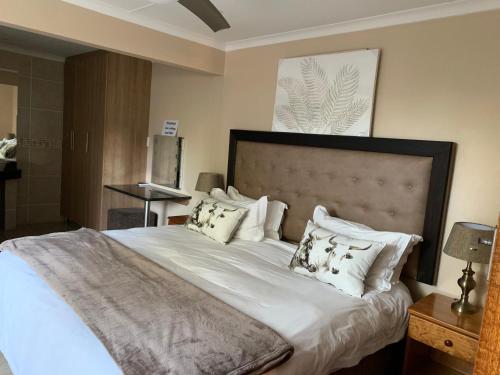a bedroom with a large bed with white sheets and pillows at TeBeacon Accommodation in East London
