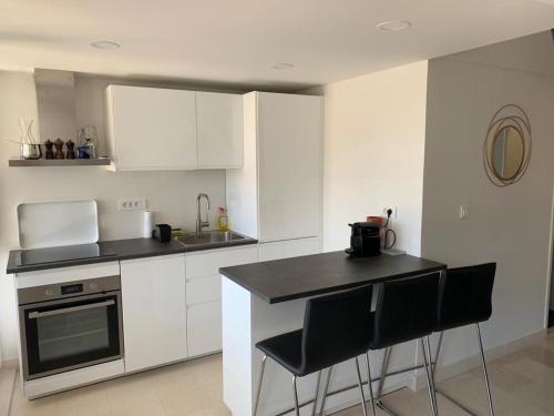 a kitchen with white cabinets and black counter tops at Penthouse in old Dalmatian house - Flybridge in Hvar