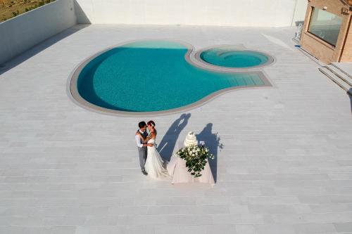 a bride and groom standing in front of a pool at Osteria dei Segreti in Appignano