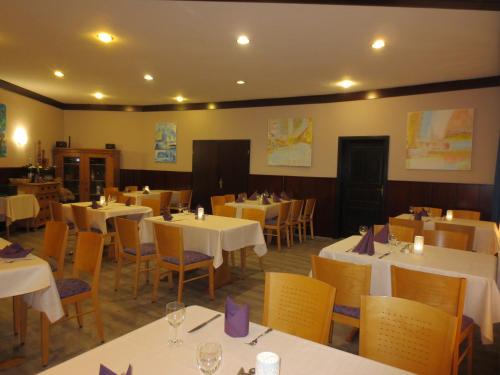 a dining room with white tables and chairs at Hotel Krone in Bad Münster am Stein-Ebernburg