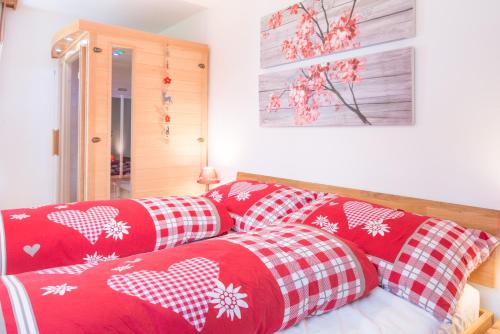 a couch with red and white pillows on it at Casa sur Plaun - 3.5 Zimmerwohnung in Sagogn