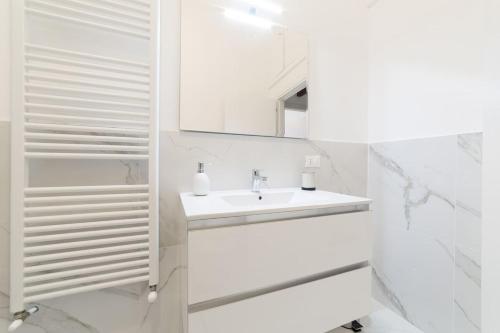 een witte badkamer met een wastafel en een spiegel bij Hill's view terrace apartment in Florence