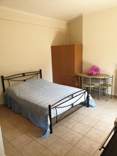 a bedroom with a bed and a table and chairs at Angela apartments in Lefkada Town