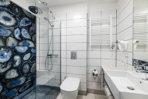 a bathroom with a toilet and a sink and a shower at Hotel Perfect in Kraków