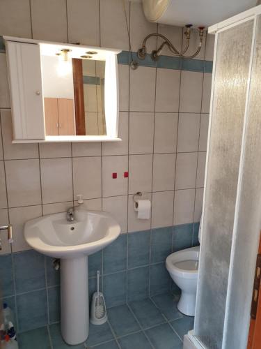 a bathroom with a sink and a toilet at Angela apartments in Lefkada Town