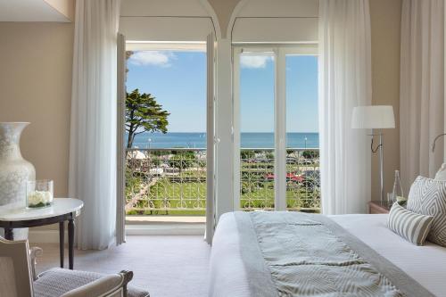 Schlafzimmer mit einem Bett und Meerblick in der Unterkunft Hôtel Barrière Le Royal La Baule in La Baule