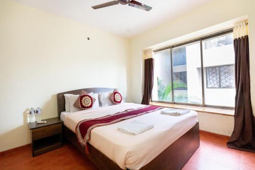 a bedroom with a large bed with a large window at Vivaant Retreat and Conventions in Igatpuri