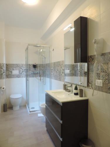 uma casa de banho com um chuveiro, um lavatório e um WC. em Pretty Tiburtina Room em Roma